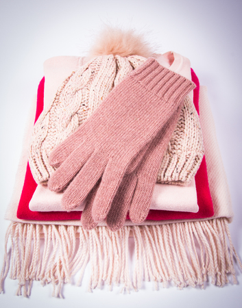 Warm winter, women's knitted clothes - hat, scarf, gloves on a white background.