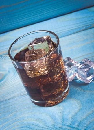 Sweet, fizzy drink with ice on a blue background. Close Up.の写真素材