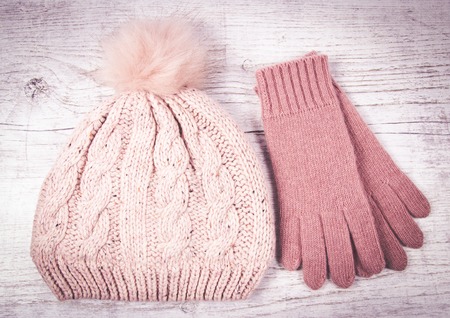 Warm winter, women's knitted clothes - hat, gloves on a wooden background.の写真素材