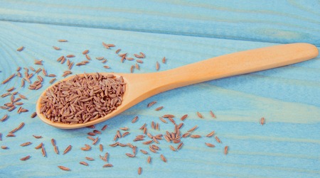 Close up on cumin in a spoon. Blue wooden background.の写真素材