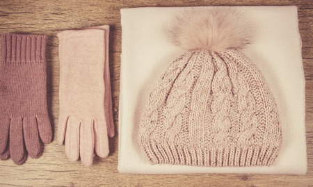 Warm winter knitted clothes: hat, scarf and gloves on a wooden background. Close Up.の写真素材