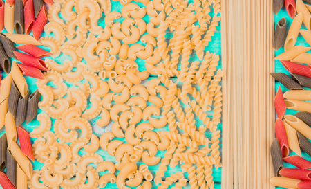 Various mix of pasta on wooden blue background. Diet and food concept.の写真素材