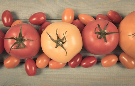 Close-up on fresh tomatoes. Different varieties and colors of tomatoes on a wood background.の写真素材