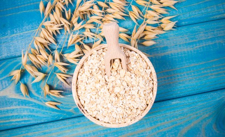 Oat and oatmeal on the wooden background. Healthy eating concept.