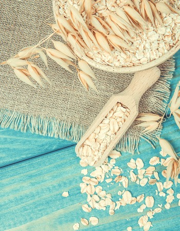 Oat and oatmeal on the wooden background. Healthy eating concept.の写真素材