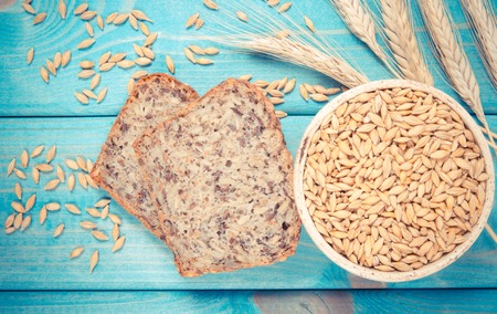 Multi-grain bread on a wooden background. The source of fiber, complex carbohydrates, B vitamins and...