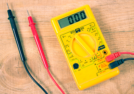 Electrician tools. Electric tester and other tools on a wooden background. The concept of repair and DIY.の写真素材