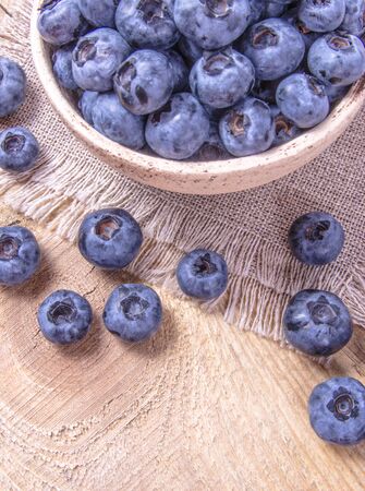 Fresh huckleberry in a bowl on a wooden background. Source of vitamins.の写真素材