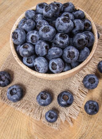 Fresh huckleberry in a bowl on a wooden background. Source of vitamins.の写真素材