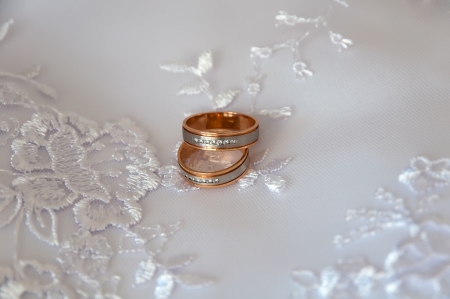 Two Wedding rings on a background of dressesの写真素材
