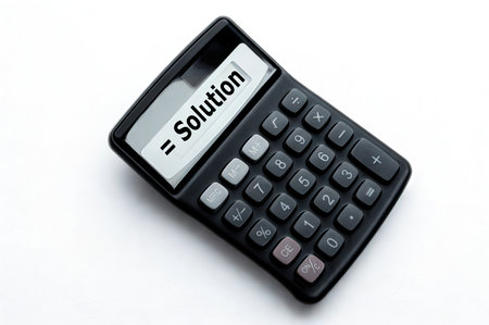 A black calculator with a screen displaying "= Solution" sits on a clean white surface, symbolizing problem-solving and answers.の写真素材