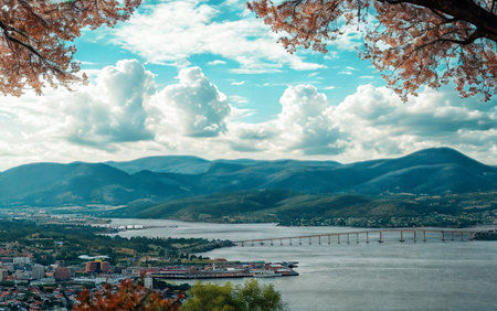 A picturesque view of a town nestled by a lake, with rolling mountains in the distance and blooming...