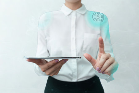 A person in a white shirt holds a thin, metallic object and gestures towards a glowing, abstract digital display with their other hand.の写真素材