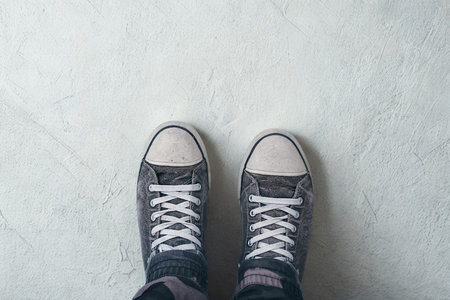 A pair of classic high top sneakers are shown from a top down perspective, standing on a light textured surface.の写真素材