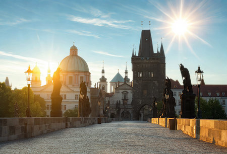 The iconic Charles Bridge in Prague bathed in the warm glow of sunrise, showcasing its historic architecture and cobblestone path.の写真素材