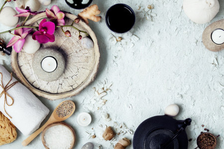 A serene flat lay of spa items including bath salts, soap, candles, and flowers, evoking tranquility and self-care.の写真素材
