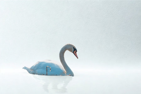 A serene, minimalist sculpture of a blue swan floats on a reflective white surface, evoking tranquility and elegance.の写真素材
