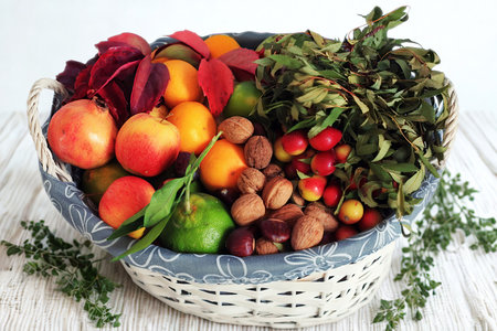 A woven basket overflows with a vibrant assortment of fresh autumn produce, including fruits, vegetables, and nuts, artfully arranged.の写真素材