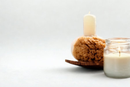A rustic loofah brush and a jar of creamy lotion sit on a wooden surface, suggesting natural spa and skincare treatments.の写真素材