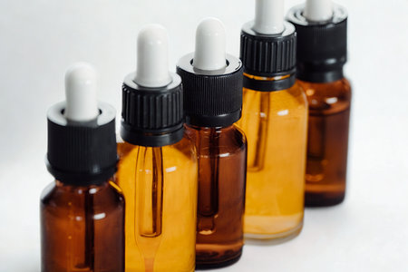 A close-up shot of amber glass bottles with white droppers, showcasing their contents against a white background.の写真素材