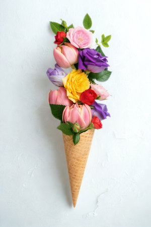 A waffle ice cream cone is overflowing with a vibrant bouquet of fresh, colorful flowers, creating a whimsical floral arrangement.の写真素材