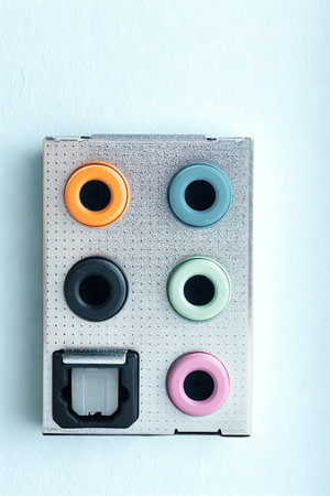 A collection of colorful silicone earbud covers and a charging port protector are arranged on a textured, light-colored surface.の写真素材