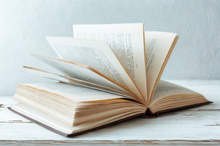 An open, aged book with its pages fanned out, suggesting movement and the act of reading or discovery.の写真素材