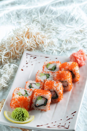 A close-up shot of several sushi rolls arranged on a white plate.の写真素材