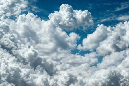 An aerial view of a vast expanse of white, puffy cumulus clouds with patches of clear blue sky visible between them.の写真素材