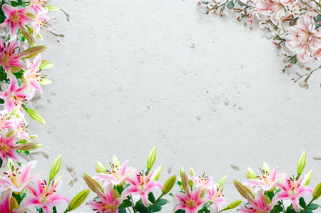 A beautiful frame of pink lilies with green stems and leaves surrounds a textured gray surface, perfect for invitations or announcements.の写真素材