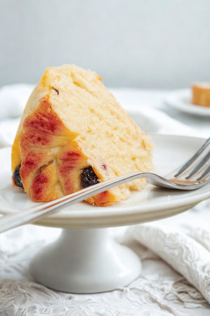 A tempting slice of bread pudding rests on a white cake stand with a fork.の写真素材