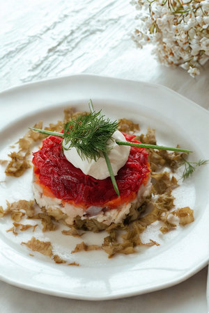 A delicate seafood dish featuring layers of fish and a creamy topping garnished with fresh dill.の写真素材