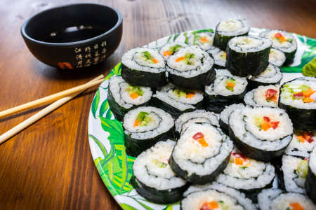 Sushi roll with salmon, avocado, cucumber, red pepper and wasabi on wooden backgroundの写真素材