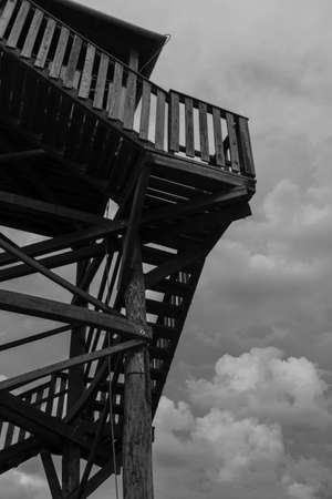 Wooden observation tower on a cloudy day. Black and white photo.の写真素材