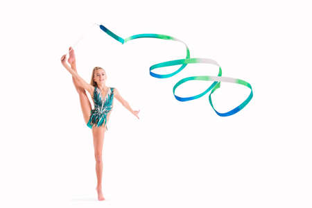 gymnast girl in an emerald swimsuit performs an exercise with a ribbon isolated on a white backgroundの写真素材