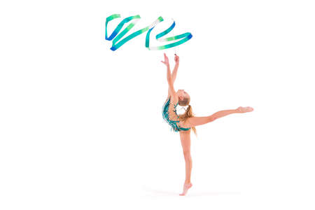 gymnast girl in an emerald swimsuit performs an exercise with a ribbon isolated on a white backgroundの写真素材