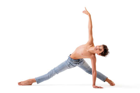 A teenage ballet dancer poses in a stretch barefoot, isolated against a white background.の写真素材