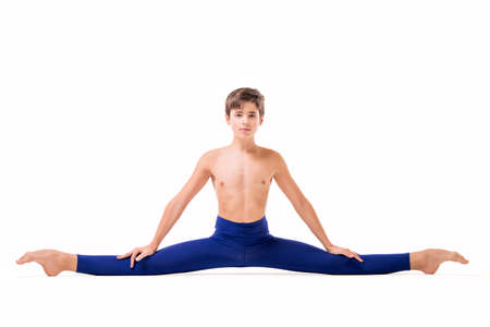 teenage ballet dancer poses in blue skin-tight tights, barefoot, isolated against white background.の写真素材