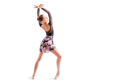 young ballerina in pointe shoes poses in graceful pose isolated on white backgroundの写真素材