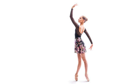 young ballerina in pointe shoes poses in graceful pose isolated on white backgroundの写真素材