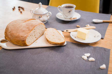 fresh loaf of bread lying on a linen towel on a wooden tableの写真素材
