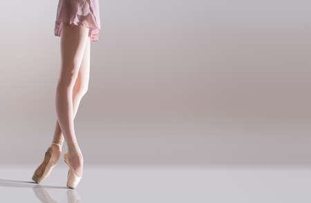Ballerina's feet in pointe shoes standing isolated on a white backgroundの写真素材