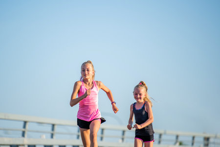 Girls compete on the asphalt road against the evening skyの写真素材
