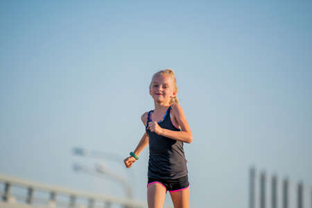 Girl runs on a sunny summer eveningの写真素材