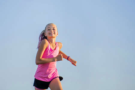 Girl runs on a sunny summer eveningの写真素材