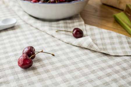 ripe red sweet cherries lying on the table in a dish and on a linen napkin.の写真素材