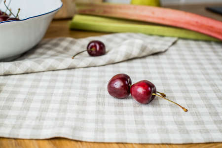 ripe red sweet cherries lying on the table in a dish and on a linen napkin.の写真素材