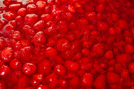 strawberry jam, red berries in syrup close-up in a copper basinの写真素材