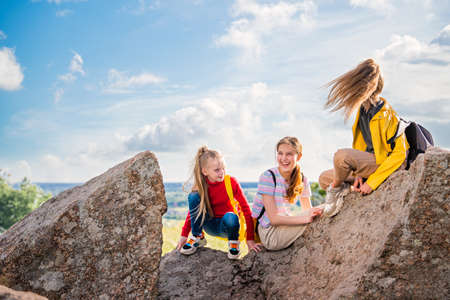 People with backpacks hiking on a summer trip to the mountains. A group of teenage girls enjoying time on a trip.の写真素材