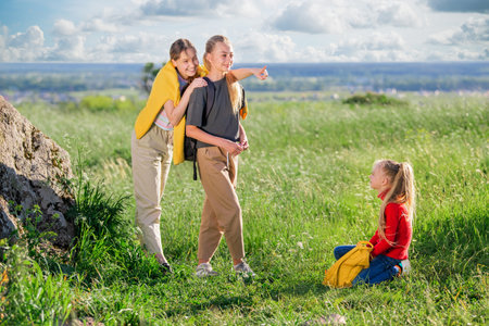 Children with backpacks on a hike on a summer trip to nature. A group of teenage girls enjoying time on a hike.の写真素材